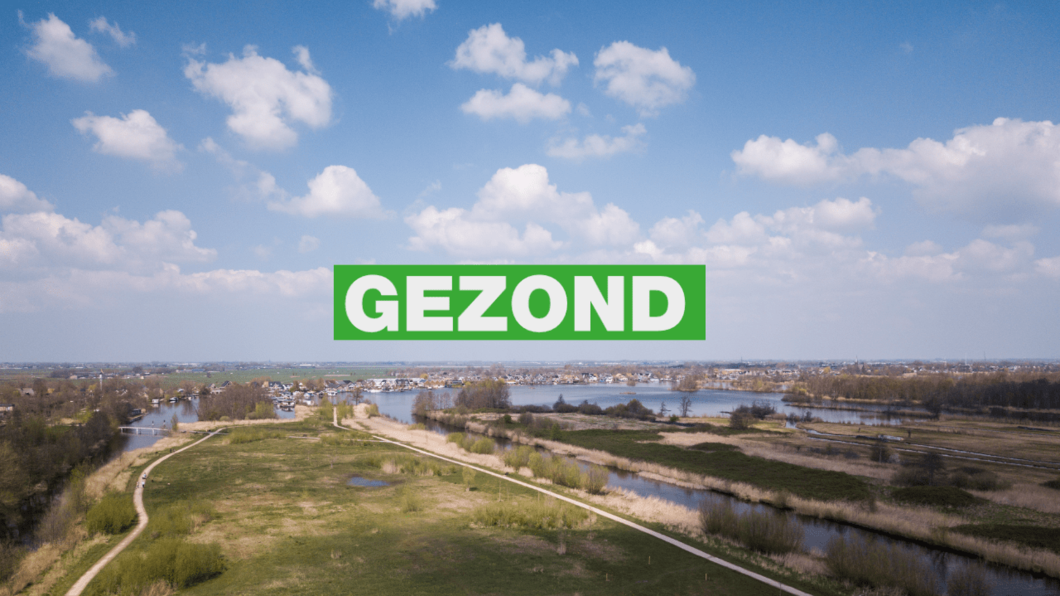 Luchtfoto van water met in de verte huizen, blauwe lucht