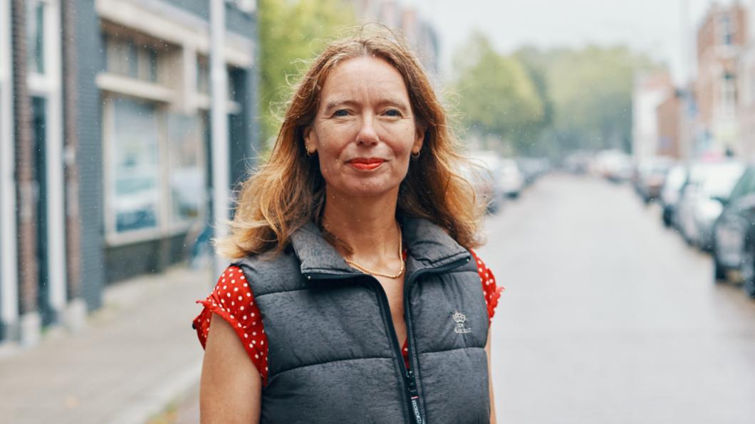 Foto van GroenLinks-Pvda gedeputeerde Anne Koning in Delft. Anne lacht en kijkt in de camera. Het regent