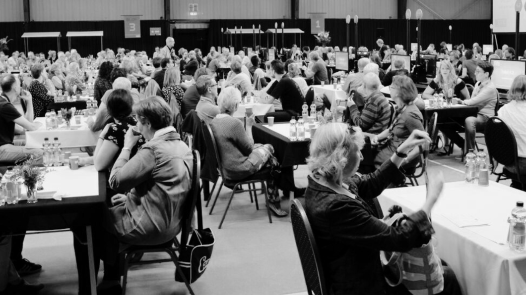 zwartwit Foto van een sessie met het burgerakkoord in 2023, mensen overleggen aan grote tafels