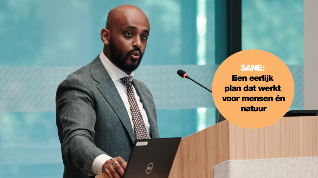 Foto van Adem Mustafa Negash die spreekt in de Statenzaal tijdens de Provinciale Staten vergadering