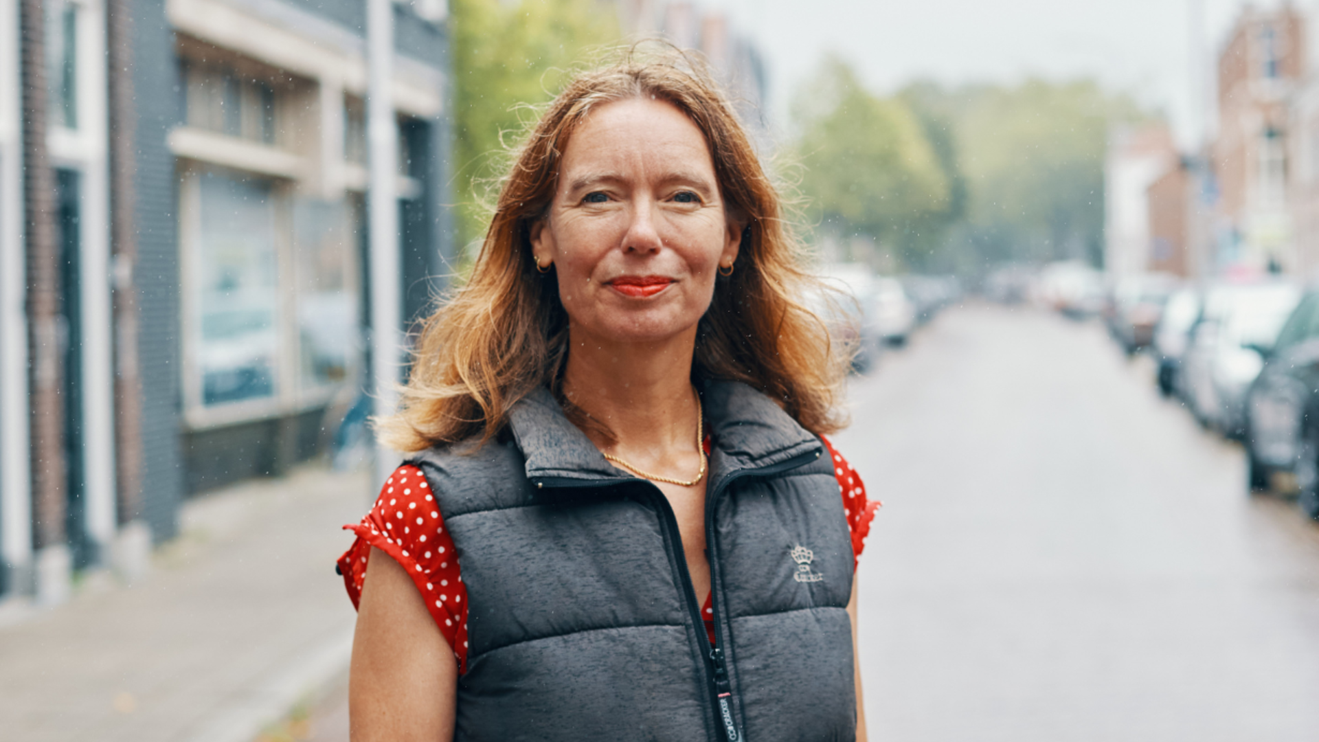 Foto van GroenLinks-Pvda gedeputeerde Anne Koning in Delft. Anne lacht en kijkt in de camera. Het regent